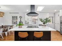 Bright kitchen features a large island with seating, modern appliances, and an eye-catching range hood at 330 Wesley Dr, Chapel Hill, NC 27516
