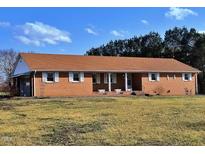 Charming brick ranch-style home with white shutters and a well-maintained front lawn on a sunny day at 3359 Huffines Dr, Burlington, NC 27217