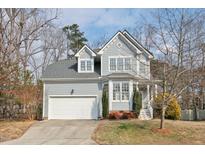 Charming two-story home with a well-maintained lawn and attached two-car garage, showcasing its classic design and curb appeal at 5806 Whispering Meadow Ln, Durham, NC 27712