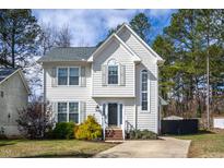 Charming two-story home with neutral siding, landscaped yard, and welcoming front entry at 7409 Wisconsin Ct, Raleigh, NC 27615