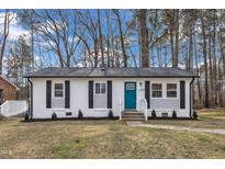 Charming renovated one-story home with a bright blue front door and black window shutters at 838 Waring St, Durham, NC 27704