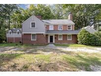 Charming brick home with a well-manicured lawn and mature trees providing ample shade and curb appeal at 938 Hargrove St, Henderson, NC 27536