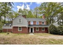 Charming two-story brick home with mature trees and a well-maintained lawn at 938 Hargrove St, Henderson, NC 27536