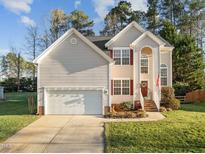 Charming two-story home featuring a well-manicured lawn and an attached two-car garage, creating a welcoming curb appeal at 1006 Scotsburg Trl, Hillsborough, NC 27278