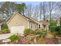 Charming single-story home featuring a two-car garage, tidy landscaping, and tan siding at 104 Chris Ct, Cary, NC 27511