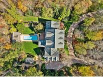 Stunning aerial view of estate, showcasing a pool, lush landscaping, circular driveway, and elegant architecture at 109 Chimeneas Pl, Chapel Hill, NC 27517