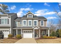 Beautiful two-story home featuring a white garage door, front porch, and manicured landscaping at 110 Gulley Glen Dr, Garner, NC 27529