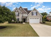 Charming two-story home featuring a manicured lawn and a spacious two-car garage at 121 Stone Nut Trl, Fuquay Varina, NC 27526