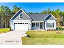 Charming single-story home with white siding, a two-car garage, and a well-manicured lawn on a sunny day at 123 Pretty Run Branch Ln, Wendell, NC 27591
