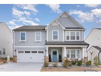 Charming two-story home featuring a welcoming front porch, a two-car garage, and manicured landscaping at 156 Bent Willow Dr, Clayton, NC 27527