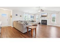 Bright living room with wood floors, fireplace, and large sectional sofa at 174 Arrow Ln, Middlesex, NC 27557