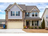Charming two-story home featuring a stone and gray siding facade, with an attached two-car garage at 1913 Brodgen Ln, Durham, NC 27703