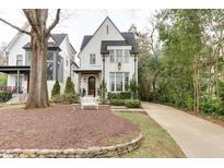 Charming two-story home with white painted brick and a well-manicured front yard featuring a quaint bench at 219 Furches St, Raleigh, NC 27607
