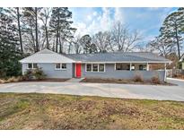 Charming single-story home with a gray brick facade, bright red door, and well-maintained front yard at 3136 Dixon Rd, Durham, NC 27707