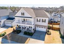 Charming two-story home with a two-car garage, a double stacked front porch, and landscaped front yard at 3418 Longleaf Estates Dr, Raleigh, NC 27616