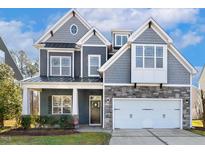 Charming two-story home featuring stone accents, gray siding and a two car garage at 4210 Massey Preserve Trl, Raleigh, NC 27616