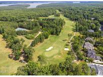 Scenic aerial view of a lush golf course community with stunning lake views surrounded by mature trees at 498 Mountain Laurel, Chapel Hill, NC 27517