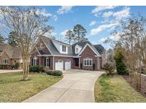 Charming brick home with a well-manicured lawn and a spacious driveway leading to a two-car garage at 498 Mountain Laurel, Chapel Hill, NC 27517