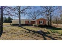 Charming single-story home with a brick facade and a well-maintained lawn surrounded by mature trees at 5436 New Oak Trl, Burlington, NC 27217