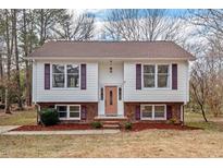 Charming two-story home featuring vinyl siding, brick foundation, and well-maintained landscaping at 7 Harrigan Ct, Durham, NC 27705