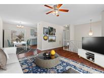 Cozy living room featuring hardwood floors, ceiling fan, and adjacent dining area with a modern table set at 7 Harrigan Ct, Durham, NC 27705