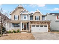 Charming two-story home with stone accents, covered porch, and a two-car garage at 8008 Hergety Dr, Raleigh, NC 27603