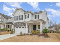 Charming two-story home with gray stone accents and a covered front porch at 824 Wrights Creek Way, Wake Forest, NC 27587