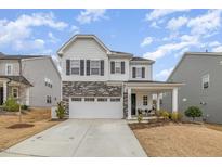 Charming two-story home with stone accents, covered porch, manicured lawn, and a two-car garage at 824 Wrights Creek Way, Wake Forest, NC 27587