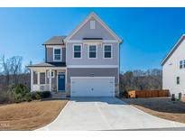 Charming two-story home with a spacious driveway and attached two-car garage at 90 Rigsby Ave, Four Oaks, NC 27524