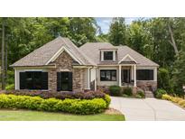 Charming home featuring stone accents, neutral siding, black shutters, and a well-manicured lawn at 946 Berry Patch Ln, Pittsboro, NC 27312