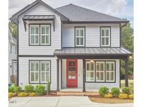 Charming two-story home with a red front door, landscaped yard, and a modern design at 1016 Addison Pl, Raleigh, NC 27610