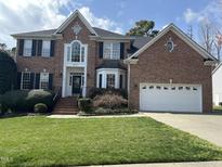 Beautiful two-story brick home with manicured lawn and attached two-car garage at 12321 Penrose Trl, Raleigh, NC 27614