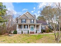 Charming two-story home with a welcoming front porch and well-maintained lawn at 153 Dell Meadows Pl, Four Oaks, NC 27524