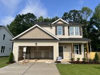 Two-story home featuring a mix of horizontal and shake siding, dark shutters, and an attached two car garage at 211 W Saltgrass Ln, Smithfield, NC 27577