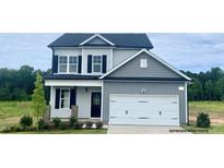 Charming two-story home features a gray exterior, black shutters, and an attached two-car garage at 211 W Saltgrass Ln, Smithfield, NC 27577