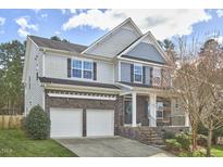 Charming two-story home with a two-car garage and stone accents on the lower level at 215 Strolling Way, Durham, NC 27707
