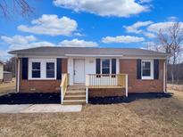 Charming single-story brick home with a cozy front porch and newly landscaped yard at 2412 Little John Rd, Raleigh, NC 27610