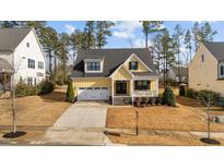 Charming yellow two-story home with a well-manicured lawn and attached two-car garage at 2500 Plowridge Rd, Fuquay Varina, NC 27526