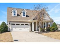 Charming home featuring a two-car garage, dormers, and manicured front yard landscaping at 345 Springtime Fields Ln, Wake Forest, NC 27587