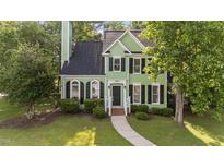 Charming two-story home with green siding, black shutters, and a well-manicured front yard at 3624 Singleleaf Ln, Raleigh, NC 27616