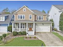 Charming two-story home featuring a welcoming front porch and attached two-car garage at 500 Skygrove Dr, Holly Springs, NC 27540