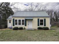 Charming home featuring a metal roof, green shutters, and a well-maintained front yard at 510 Short W St, Hillsborough, NC 27278