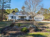 Charming single-story home with white siding, grey roof, and well-maintained landscaping at 5715 Sky Lane Dr, Durham, NC 27704