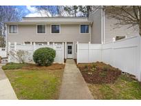 Charming townhouse with a white fence, walkway, and manicured landscaping at 7317 Sandy Creek Dr, Raleigh, NC 27615