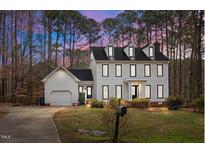 Two-story home with a black roof, dormer windows, and an attached garage with a beautiful lawn at 7904 Kingsland Dr, Raleigh, NC 27613