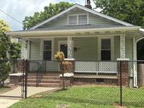 Charming single-story home featuring a cozy front porch with decorative columns and a well-maintained yard at 907 Holloway St, Durham, NC 27701