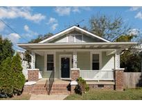 Charming bungalow with a covered front porch with brick and decorative columns at 907 Holloway St, Durham, NC 27701