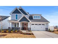 Charming two-story home featuring stone accents, a red front door, and a two-car garage with detailed trim at 9160 Dupree Meadow Dr # 13, Angier, NC 27501