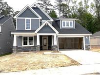 New two-story home with blue siding, stone accents, covered entry, and attached two car garage at 9160 Dupree Meadow Dr # 13, Angier, NC 27501