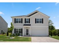 Charming two-story home boasts a manicured lawn and an attached two-car garage at 10 Forest Brook Way, Clayton, NC 27520
